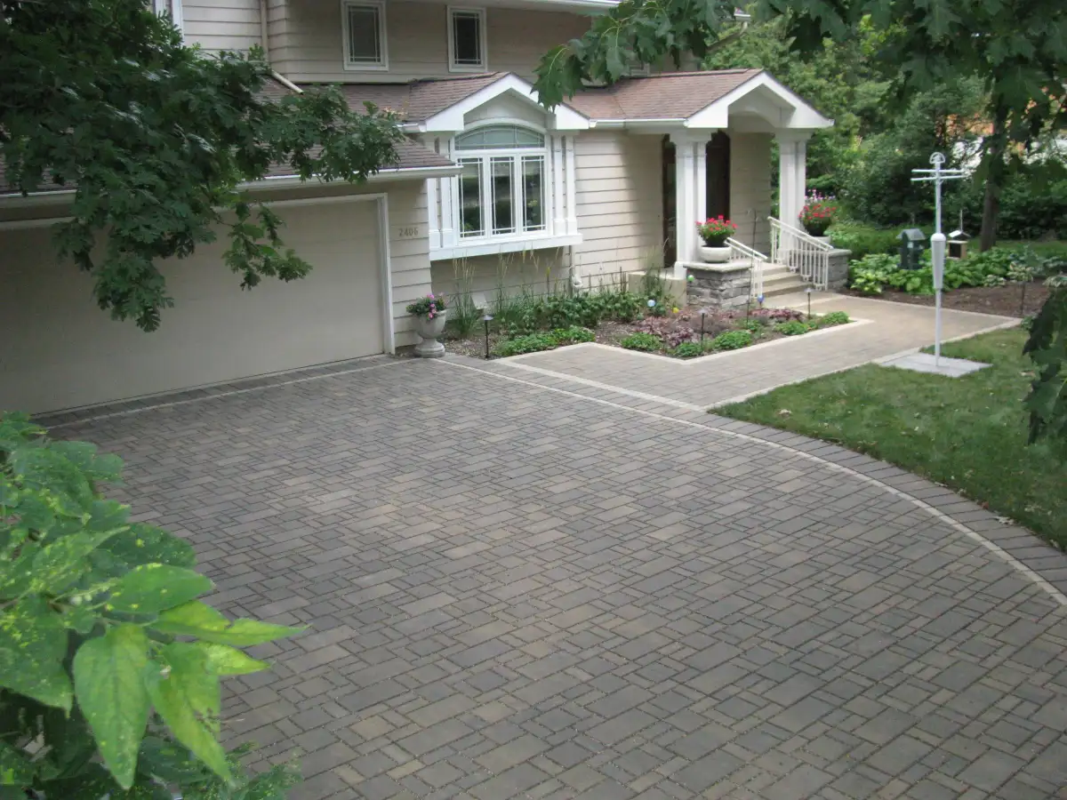 Gray paver driveway with border detail and foundation plantings